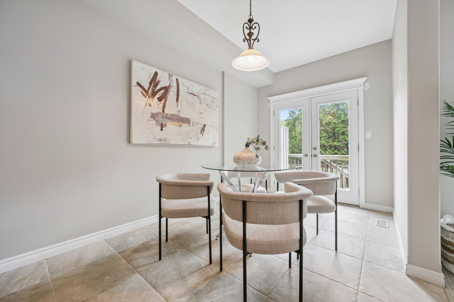 Dining area with glass table and double doors leading to the private deck