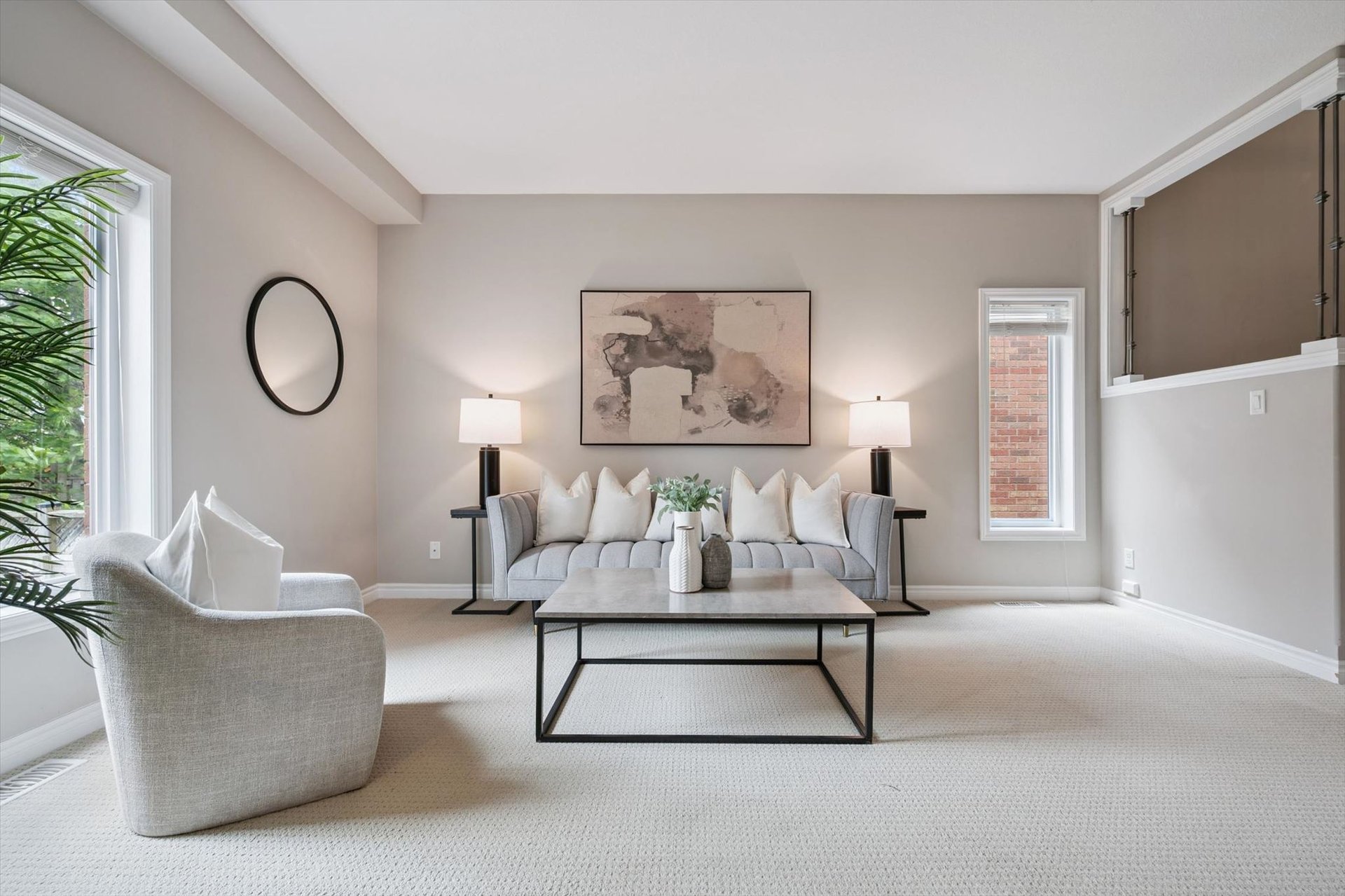 Sun-filled living room with neutral furnishings and oversized windows at 28–146 Downey Road, Guelph